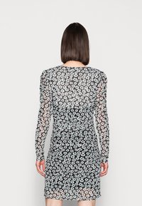 Schwarzes Blumenkleid mit langen Ärmeln, das eine durchsichtige Textur aufweist und mit kleinen weißen und hellblauen Blumenmustern bedeckt ist.