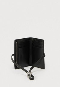 Μαύρο δερμάτινο πορτοφόλι με φερμουάρ και θήκες για κάρτες. Διαθέτει αφαιρούμενο λουράκι και μινιμαλιστικό σχεδιασμό χωρίς εμφανές λογότυπο.