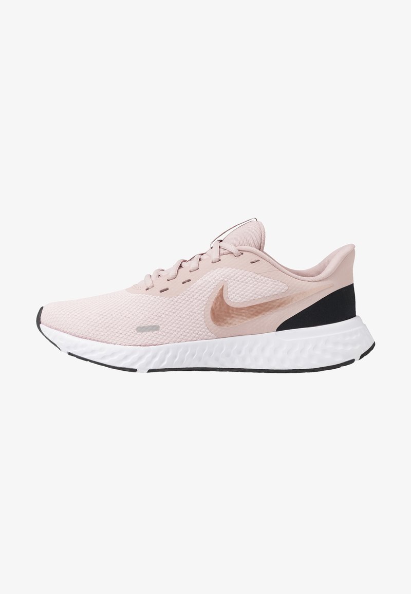 Chaussure de running Nike rose clair avec semelle blanche texturée, détail talon noir et logo Nike swoosh rose sur le côté, vue de l'extérieur.