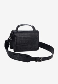 Sac à main en cuir noir à motif crocodile avec poignée supérieure et bandoulière réglable à boucle, posé sur un fond blanc.