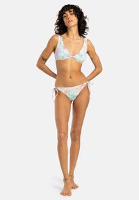 Bikini-set med triangeltopp och sidsnören i pastellfärger med tropiska bladmönster. Slät tygtextur.