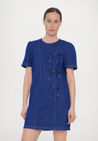 Blue denim dress with short sleeves, fitted shape, three decorative bows along the front, and contrasting stitching details.