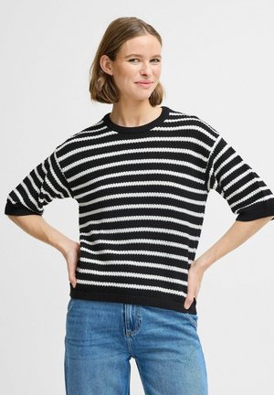 Schwarz-weißer gestreifter Strickpullover mit kurzen Ärmeln, rundem Ausschnitt und einfarbigem schwarzen Saum. Getragen mit hellblauen Jeans.