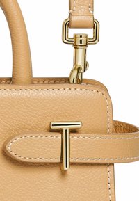Piccola borsa a tracolla in pelle beige con finiture dorate, caratterizzata da un accento dorato a "T" e cuciture bianche lungo i bordi.