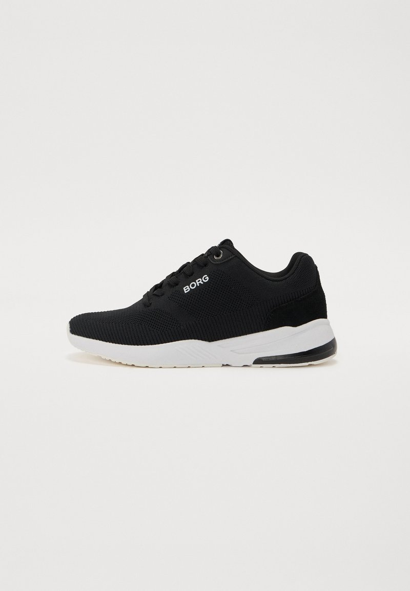 Sapatos de desporto pretos com um upper em malha texturizada, sola branca e uma marcação subtil. Design de baixo perfil e colarinho almofadado para conforto.