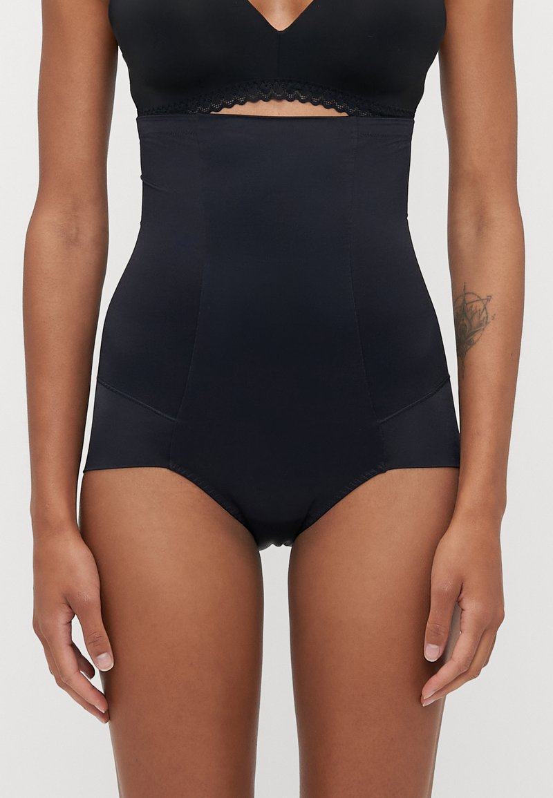 Shorts modeladores pretos de cintura alta feitos de tecido suave, com um design sem emendas e um acabamento decorativo na parte superior. Não contém elementos metálicos visíveis.