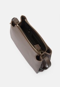 Bolsa de mão de couro castanho com acabamento texturizado, fecho de zip na parte superior, duas alças curtas e forro interior preto com um bolso com zip.