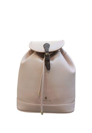 Zaino in pelle beige con coulisse, patta e cinturino scuro con fibbia, marchiato "L'Atelier du Sac" sulla parte anteriore, centro inferiore.