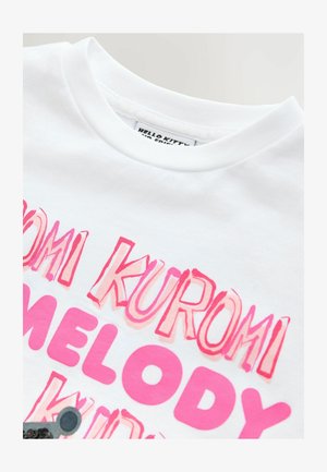 Balts kokvilnas T-krekls ar izteiksmīgu rozā tekstu, kas lasa "KURMI MELODY KID" ar slāņainu gradienta efektu un noapaļotu kakla izgriezumu.