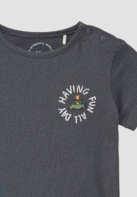 Dunkelgraues Babykleidchen mit Druckknöpfen an der Schulter, mit einem kleinen grünen Auto, einer Giraffe und dem Text "DEN GANZEN TAG SPASS HABEN" in einem Kreis.