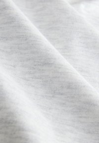 Light gray fabric with a smooth, soft texture featuring subtle variations in tone, creating a marled effect throughout.