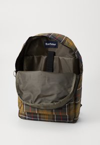 Zöld és barna kockás hátizsák, nyitott fő rekesszel, belső párnázott laptoptokkal és Barbour márkájú címkével belül.