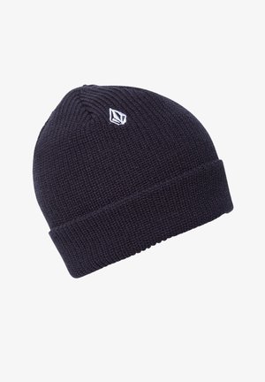 Ciemnoniebieska dzianinowa czapka beanie z podwiniętym rondem i małym białym haftowanym logo blisko góry.
