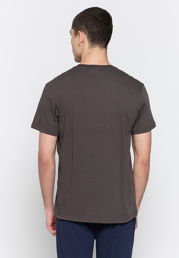 Camiseta de algodón gris oscuro con mangas cortas y cuello redondo, que presenta un corte relajado y una textura suave. Sin patrones ni gráficos visibles.