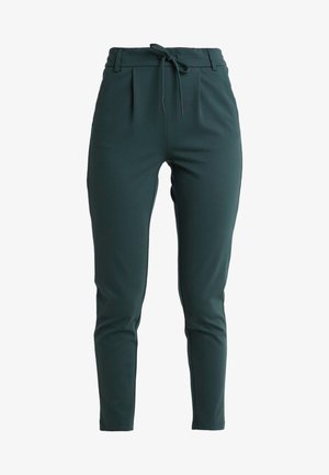Dark green, stretchy tapered pants with a drawstring waist, subtle pleats, and smooth texture. No visible patterns or hardware details.