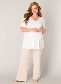 Witte V-hals top met korte mouwen, gecombineerd met beige wijde broek. Glad, lichtgewicht materiaal met een ontspannen pasvorm. Natuurlijke glans.