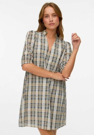 Abito a quadri beige con maniche a sbuffo corte, scollo a V e vestibilità ampia. Presenta motivi a quadri neri e blu su tutta la stoffa.