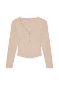 Top de manga larga de color beige con relieve, escote en V y cinco botones a lo largo de la tapeta. Textura suave y dobladillo cortado con bordes redondeados.