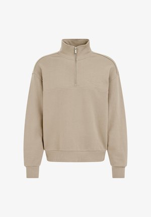 Bež dolg rokav pulover z zadrgo do četrtine, stoječim ovratnikom, rebrastimi manšetami in spodnjim delom ter nežnim vezenim napisom na levi strani prsi.