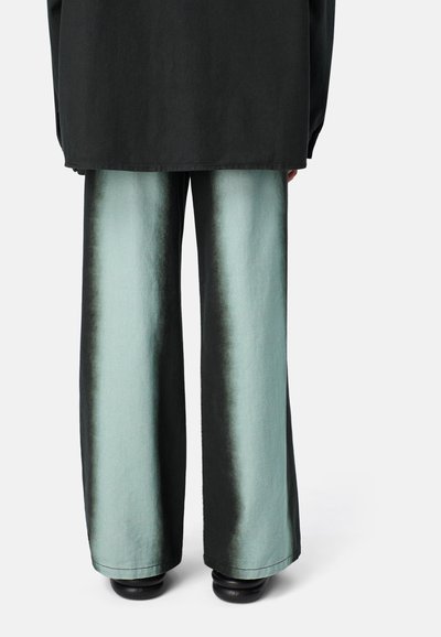 Kalhoty širokého střihu s gradientním designem přecházejícím z černé do tyrkysové, vyrobené z hladké tkaniny, s jemným leskem a čistým lemem.