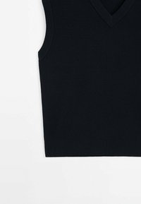 Veste sans manches noire en maille avec col en V et bords côtelés sur fond blanc.