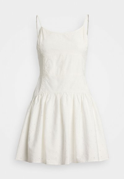 Valge ilma varrukateta kleit, millel on sobiv bodži, laienev seelik, tekstureeritud kangas, lilleline tikand ja väikesed lõikega detailid üle kogu kleidi.