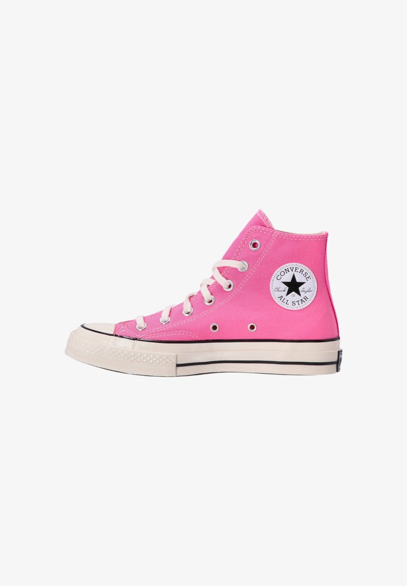 Baskets montantes Converse All Star roses avec lacets blancs, semelle en caoutchouc et patch logo noir sur le côté.