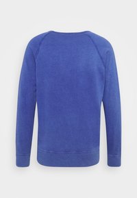 Sudadera azul de manga larga, cuello redondo y puños acanalados. Presenta una textura suave y un diseño minimalista. Vista trasera.