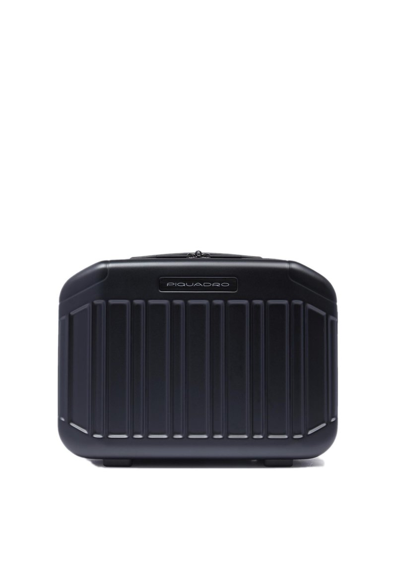 Zwarte harde koffer met verticaal geribd ontwerp. Voorzien van een zilverkleurig merkembleem aan de voorkant en een veilige ritssluiting aan de bovenkant.