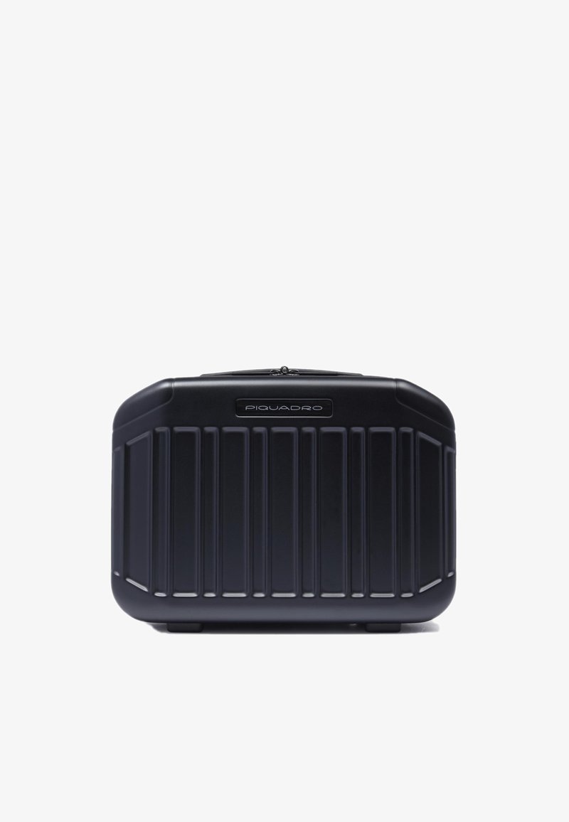 Zwarte harde koffer met verticaal geribd ontwerp. Voorzien van een zilverkleurig merkembleem aan de voorkant en een veilige ritssluiting aan de bovenkant.