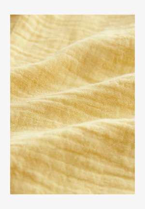 Heled kollane kangas, millel on tekstuuriga ja kortsus välimus. Pehme, kerge materjal, millel on kerge läige ja kootud muster.