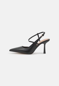 Černé kožené slingback podpatky s špičatou špičkou, tenkým křížovým páskem a 9 cm vysokým stiletto podpatkem. Hladká textura s minimalistickým designem.
