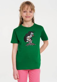 Green cotton t-shirt featuring a cartoon mole character digging with a small shovel, set against a simple background. Short sleeves.