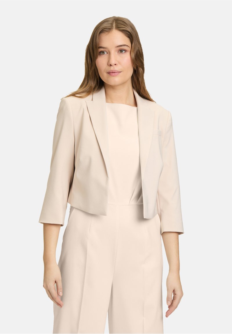 Beige cropped blazer met een sjiekraag, driekwart mouwen en een gladde textuur. Eenvoudig ontwerp zonder zichtbare patronen of hardware.