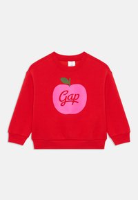 Sweatshirt roșu din bumbac, cu un grafic mare al unei mere roz, având o frunză verde și cuvântul "Gap" scris cu litere cursive albe.