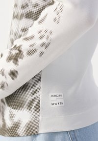 Witte sporttop met lange mouwen, gekenmerkt door een textuurdesign met bruine stippenpatronen. Inclusief een MarcCain Sports logo-label aan de zijkant.