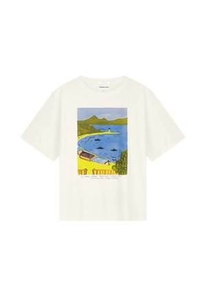 Weißes T-Shirt mit bunter Küstenillustration, die Berge, Boote im blauen Wasser, Strandhäuser und grüne Landschaft zeigt.