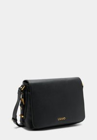 Borsa a tracolla in pelle nera con superficie texturizzata, dettagli in hardware dorato e chiusura a patta. Presenta una tracolla regolabile e dettagli con logo.