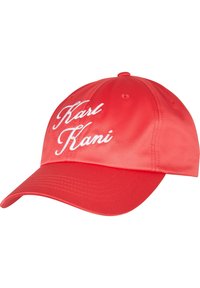 Fényes anyagból készült piros sapka, elöl fehér hímzett "Karl Kani" felirattal. Görbültnapellenző és szellőzőnyílások a koronán.