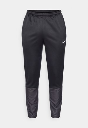 Pantalones atléticos negros con un tejido texturizado, cinturilla elástica y paneles inferiores lisos. Presentan un pequeño logo blanco de Nike en la parte frontal.