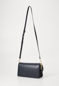 Sac bandoulière en cuir bleu marine avec une texture lisse, de forme rectangulaire et une bandoulière réglable. Dispose de détails en métal doré et d'un compartiment zippé.