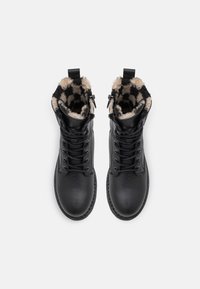 Czarne buty sznurowane z textured skóry, z wzorzystym kołnierzem z sztucznego futra i zamkami po bokach.
