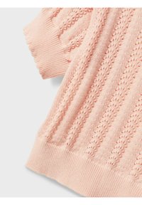 Maglione lavorato a maglia rosa chiaro con un motivo testurizzato. Presenta maniche corte e polsini e orlo a costine. I dettagli includono sezioni a giorno.