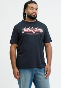 Mustal puuvillane T-särk, mille eest leidub silmapaistev valge ja punane graafiline print "Jack & Jones". Lühikeste varrukatega ja ringsuuga kaelus.