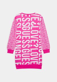 Helles pinkes langärmliges Kleid mit auffälligen weißen Textmustern, die die Wörter "GUESS", "LOVE" und "LOS ANGELES" auf der Vorderseite und den Ärmeln wiederholen.