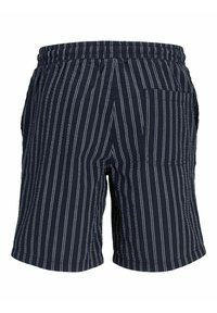 Tamsiai mėlynos šortai su baltais vertikaliais dryžiais, elastinga juosmens juosta ir vienu užpakaliniu kišeniu. Audinio tekstūra atrodo lengva ir kasdieniška.