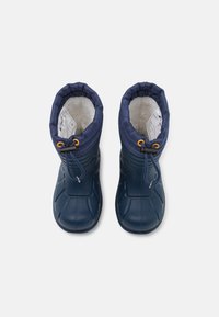 Bottes imperméables navy avec un extérieur en caoutchouc texturé, doublure en polaire et un haut resserré avec cordon de serrage et accents en métal doré.