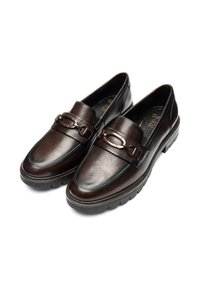Een paar donkerbruine leren loafers met stevige zwarte zolen en een gouden metalen paardenbitdetail bovenop.