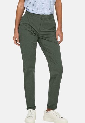 Chinos in cotone verde oliva con una vestibilità slim, dotati di passanti per la cintura, due tasche anteriori e texture del tessuto evidente. Abbinati a sneakers bianche.