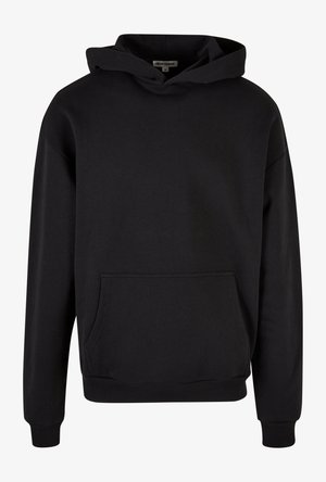 Melns kapucis ar mīkstu audumu, kas ir aprīkots ar priekšējo kabatu, ribotām aprocēm un apakšmalu, kā arī ar aukliņu kapuci un brīvu piegriezumu.